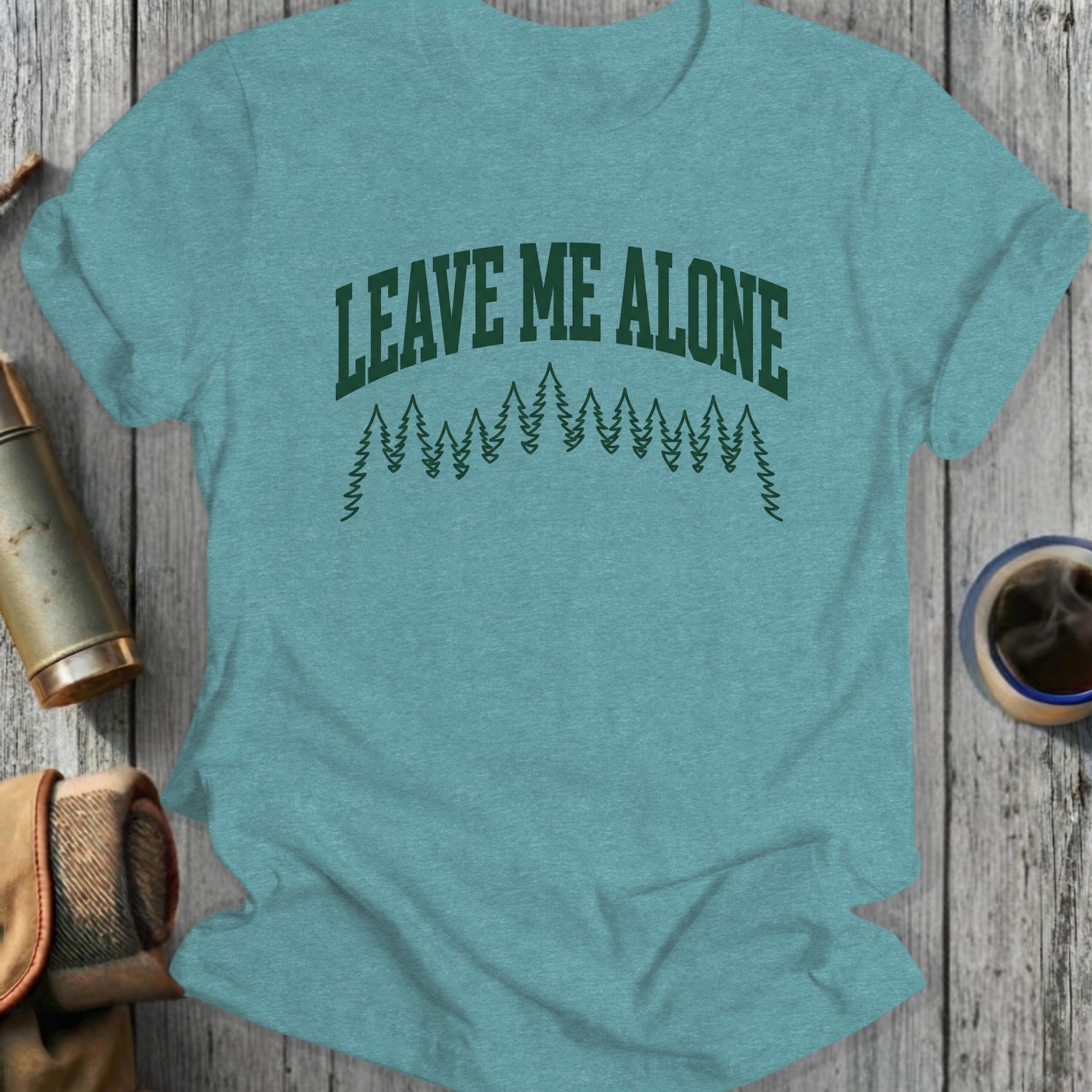 Teal t-shirt with "Leave Me Alone" text and pine tree graphic.
