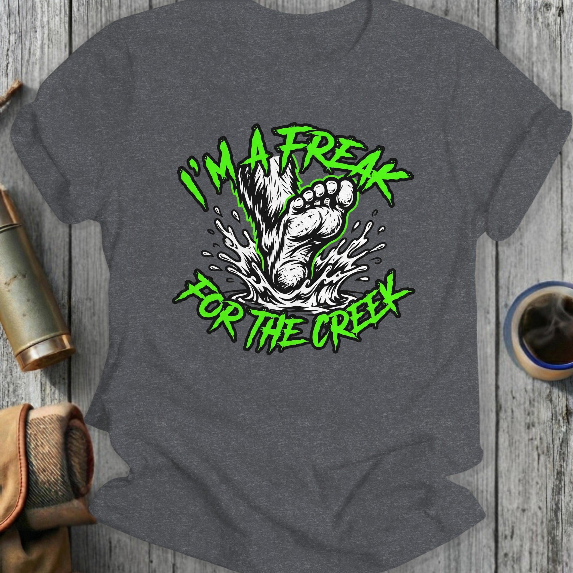 T-shirt graphic with green text "I'm a freak for the creek" above a splashing footprint.