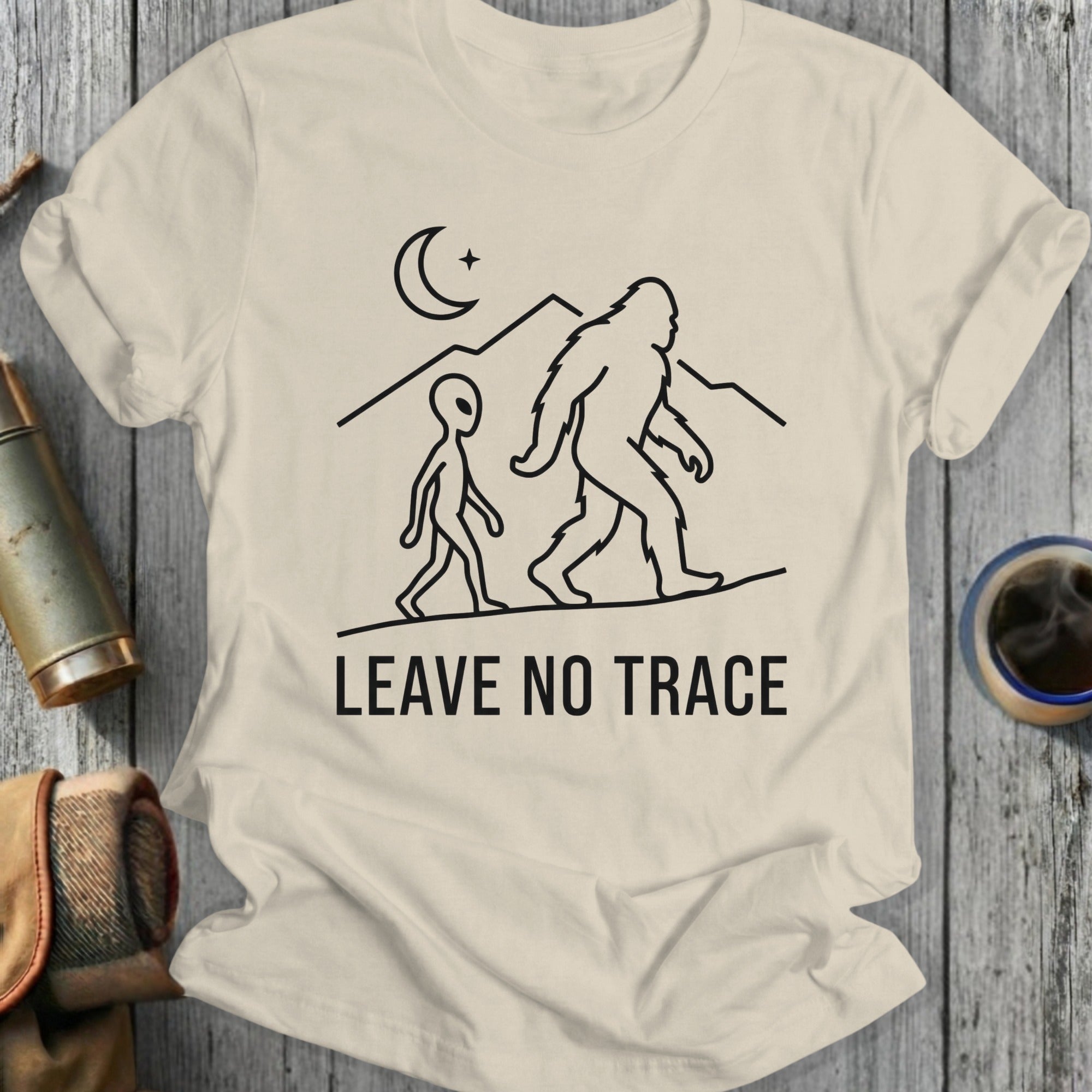 Alien and Bigfoot walk across mountains under a crescent moon, "LEAVE NO TRACE".