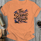 Orange t-shirt with "The Scenic Route" text and mountain landscape graphic.