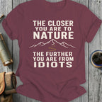 Maroon t-shirt with text: "THE CLOSER YOU ARE TO NATURE THE FURTHER YOU ARE FROM IDIOTS"