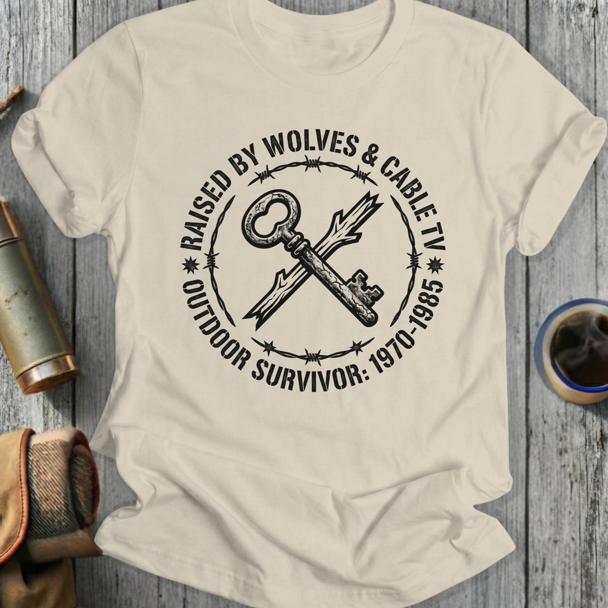 T-shirt with key and barbed wire design, "Raised by Wolves & Cable TV"