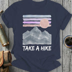 Navy t-shirt with watercolor mountains, sun, and "TAKE A HIKE" text.