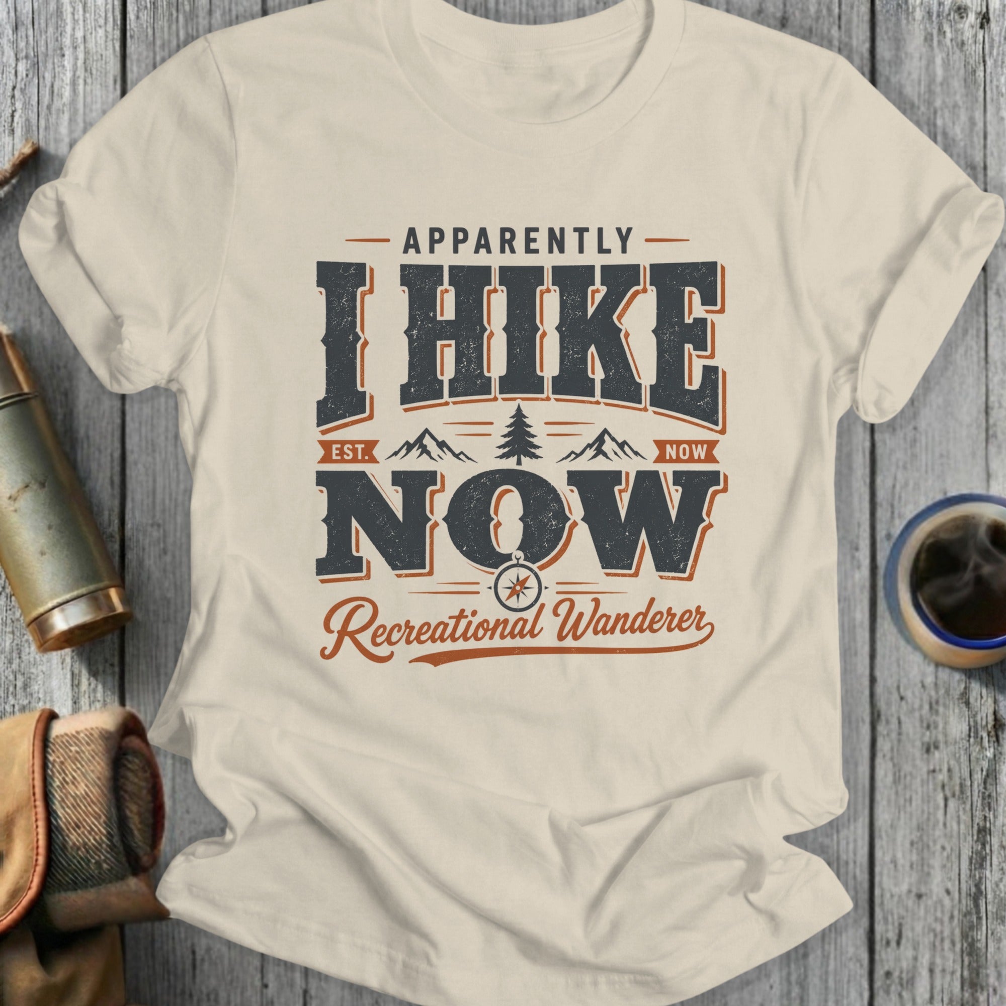 T-shirt with "Apparently I Hike Now Recreational Wanderer" text, mountains, and compass.