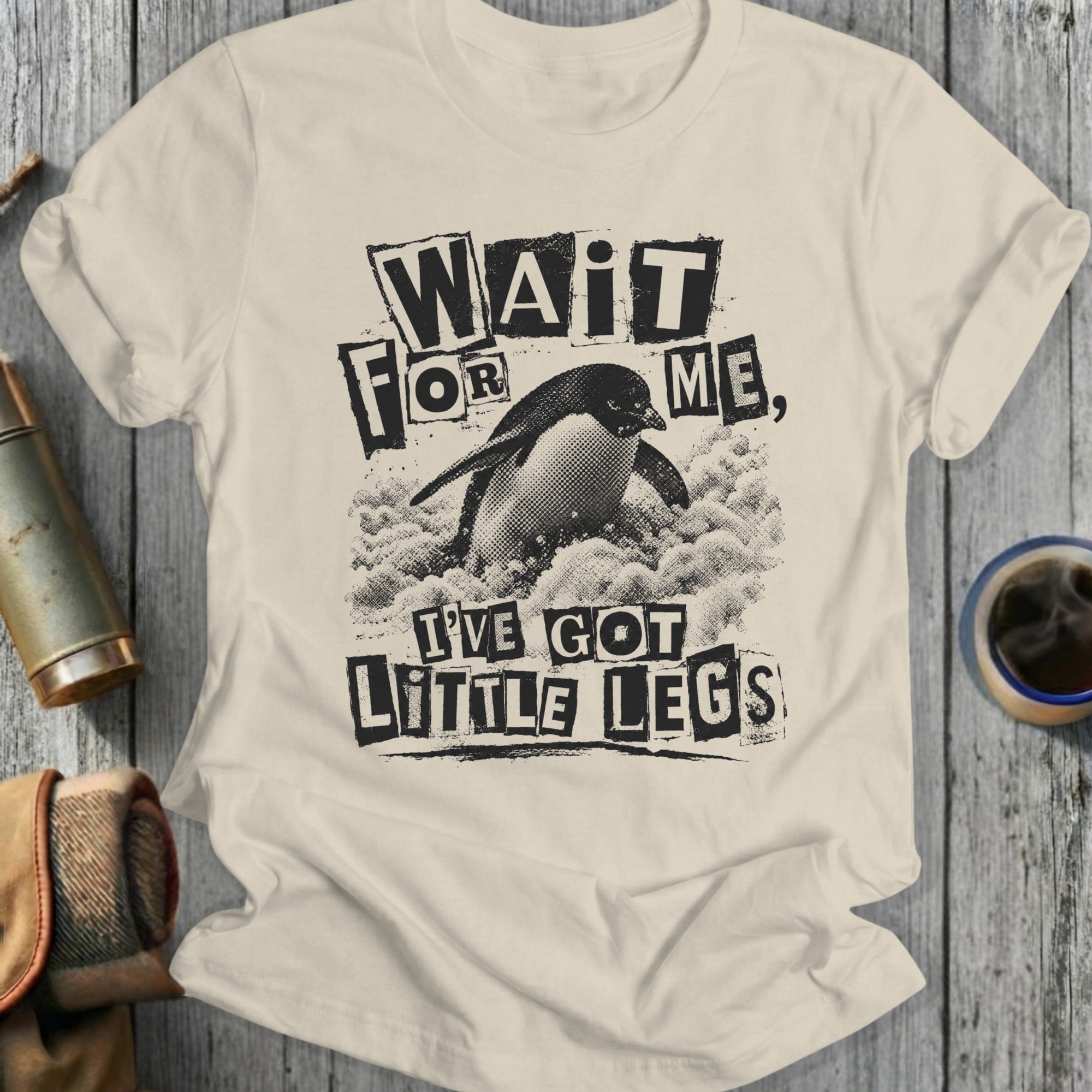 Cream t-shirt with a distressed graphic of a penguin and the text "Wait for me, I've got little legs".