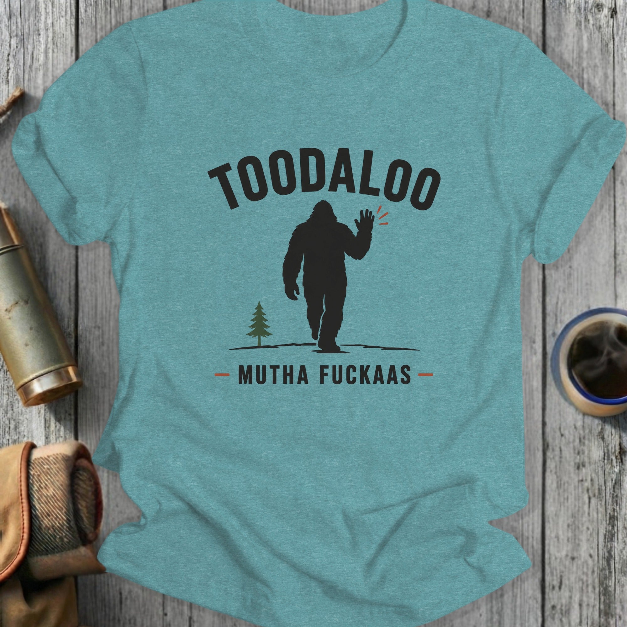 Teal t-shirt with Bigfoot graphic saying "TOODALOO MUTHA FUCKAS".
