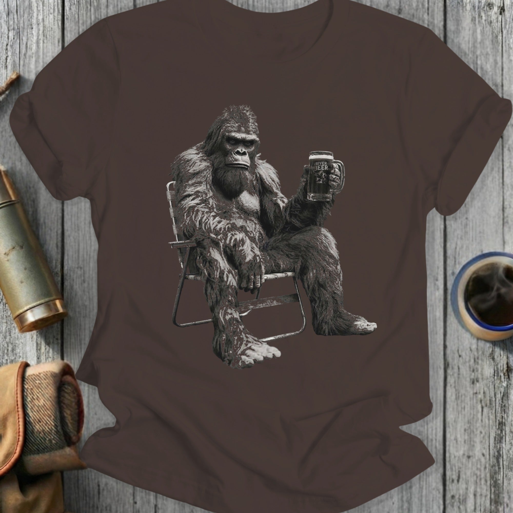 Bigfoot sitting in a chair, holding a mug of beer.