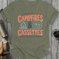 Olive green t-shirt with "raised on CAMPFIRES & CASSETTES good times, bad directions" text.