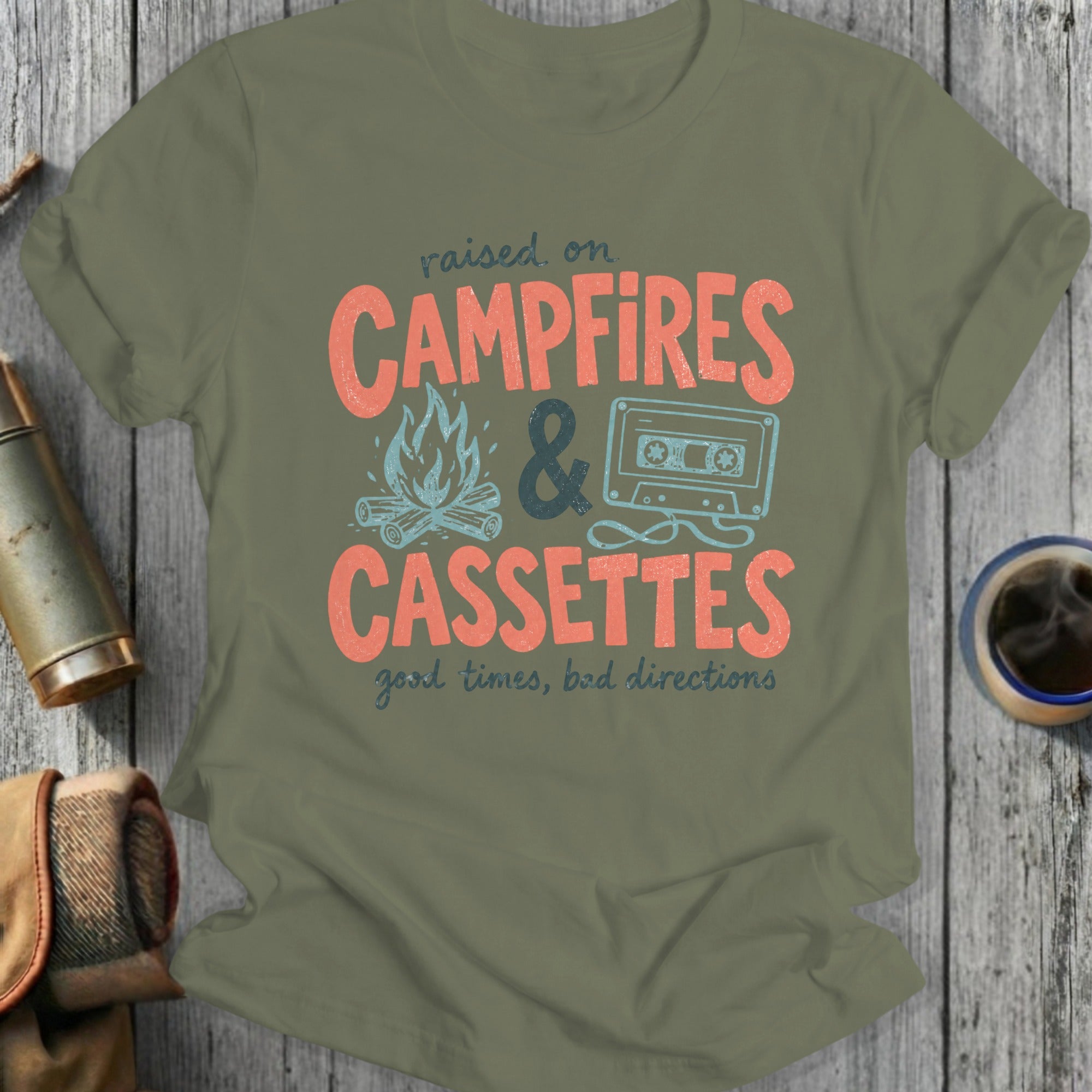 Olive green t-shirt with "raised on CAMPFIRES & CASSETTES good times, bad directions" text.