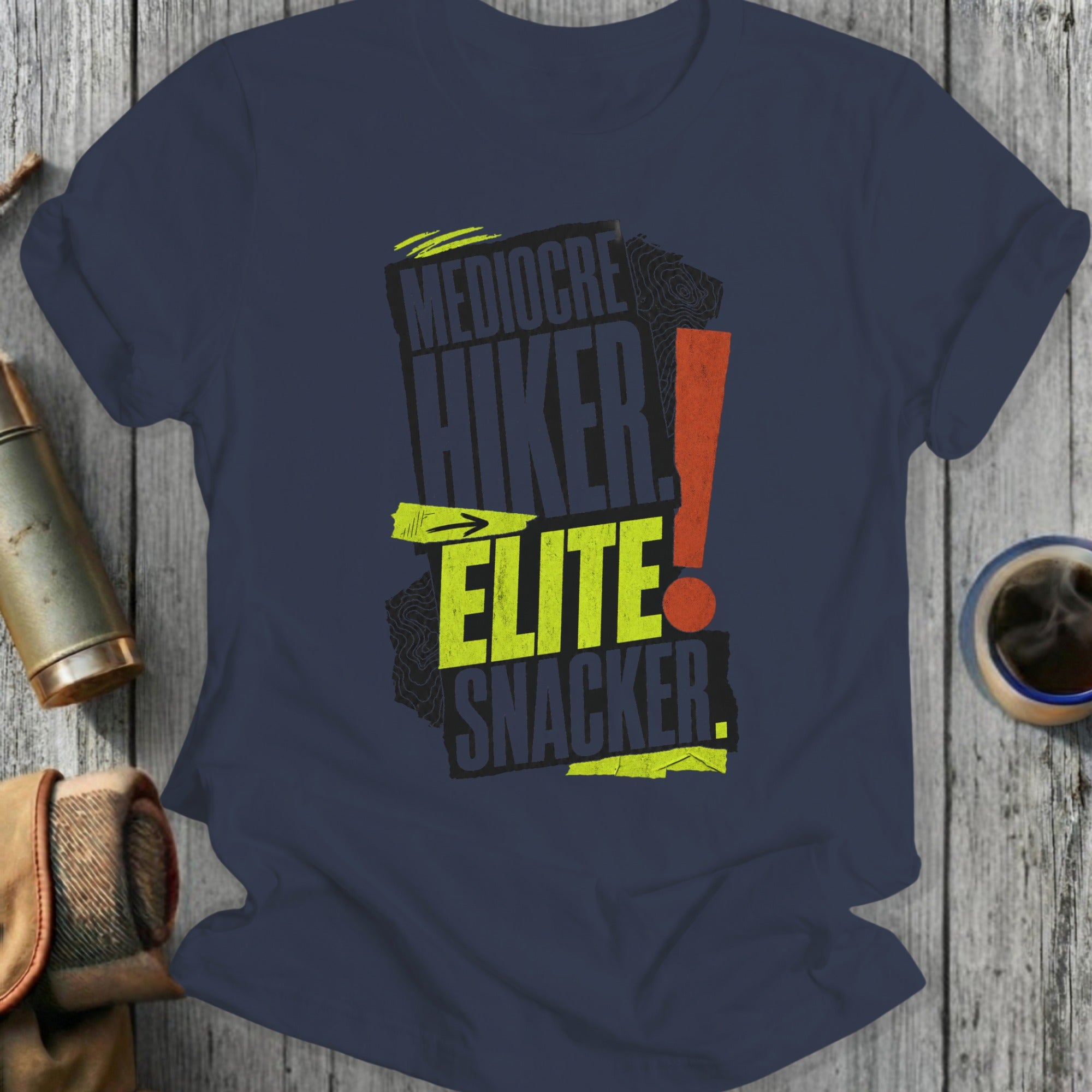 Navy t-shirt with "Mediocre Hiker! Elite Snacker." text and red exclamation mark.