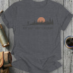 Dark grey t-shirt with sunset, pine trees, and "NOT LOST. JUST LISTENING." text.