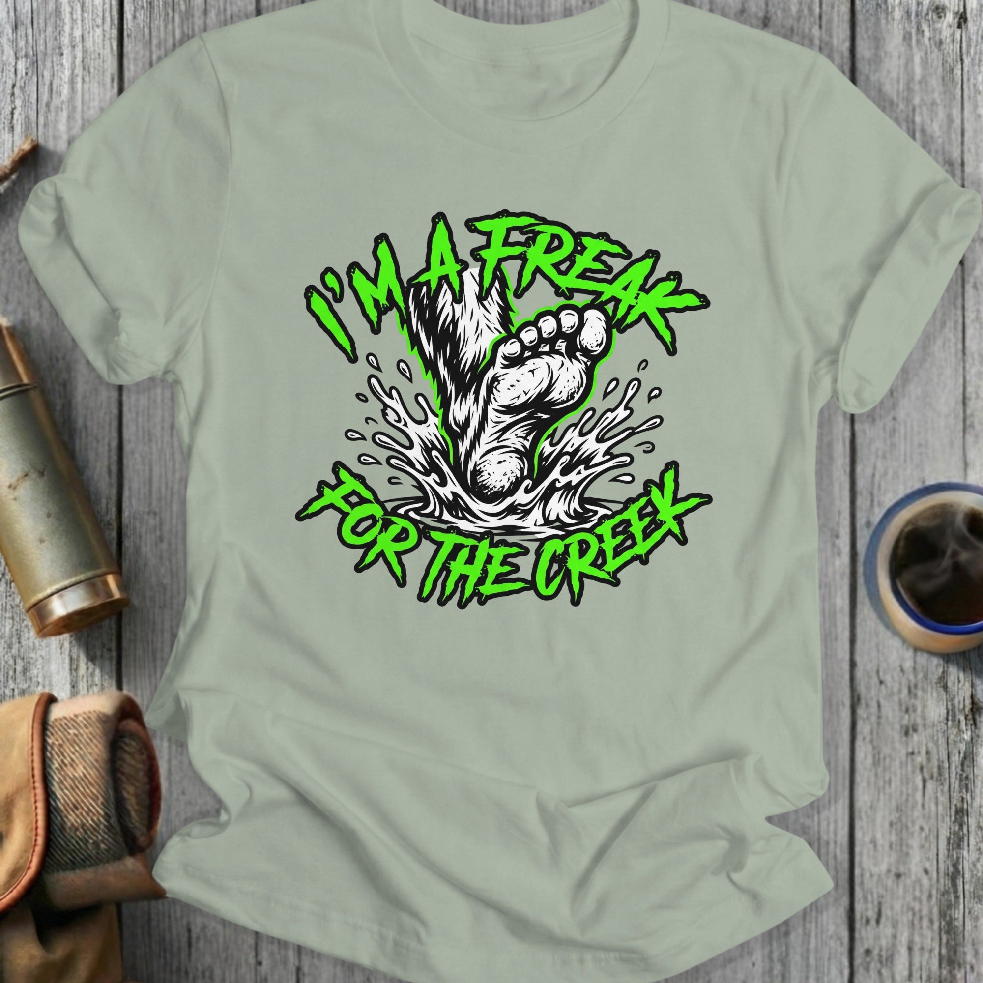 Green text on t-shirt reads "I'm a freak for the creek" with a splashing footprint.