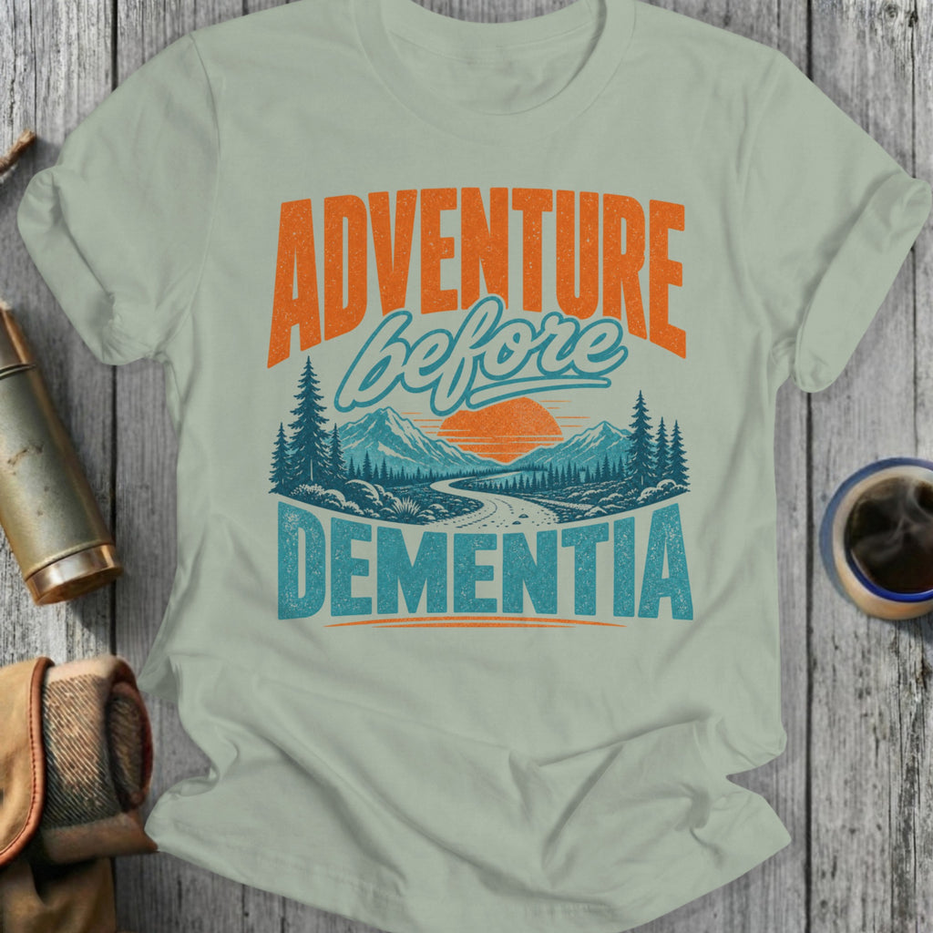 Light green t-shirt with "ADVENTURE before DEMENTIA" and mountains graphic.