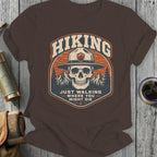 Brown t-shirt with skull, mountains, and text "Hiking Just Walking Where You Might Die".