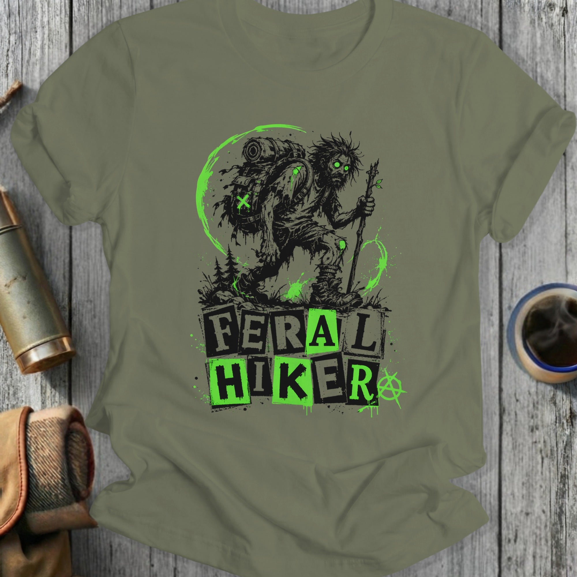 Feral Hiker graphic on olive green t-shirt with backpack and staff.