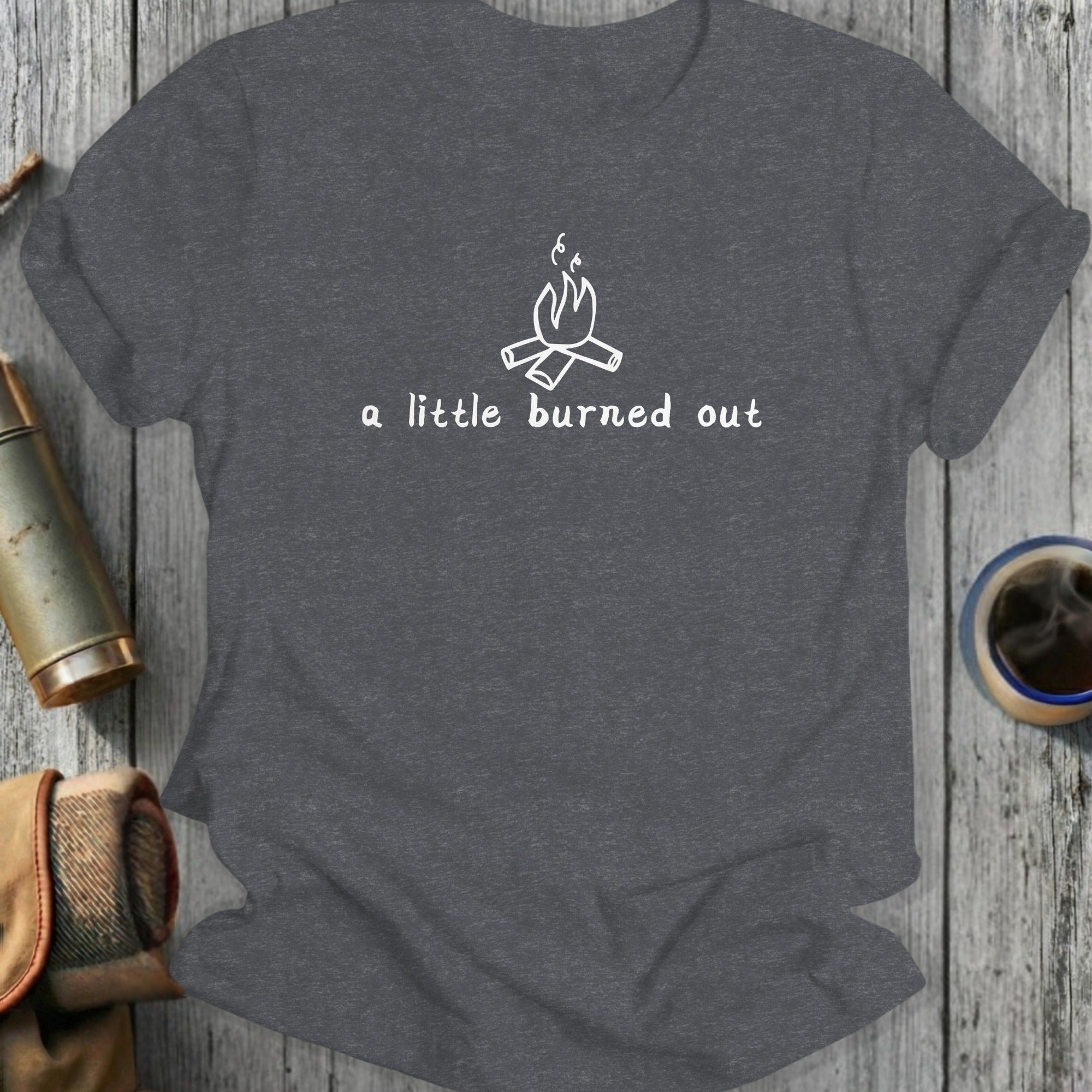 Gray t-shirt with a white line drawing of a campfire and text "a little burned out".