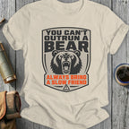 Cream t-shirt with graphic of bear and text "You Can't Outrun a Bear Always Bring a Slow Friend".
