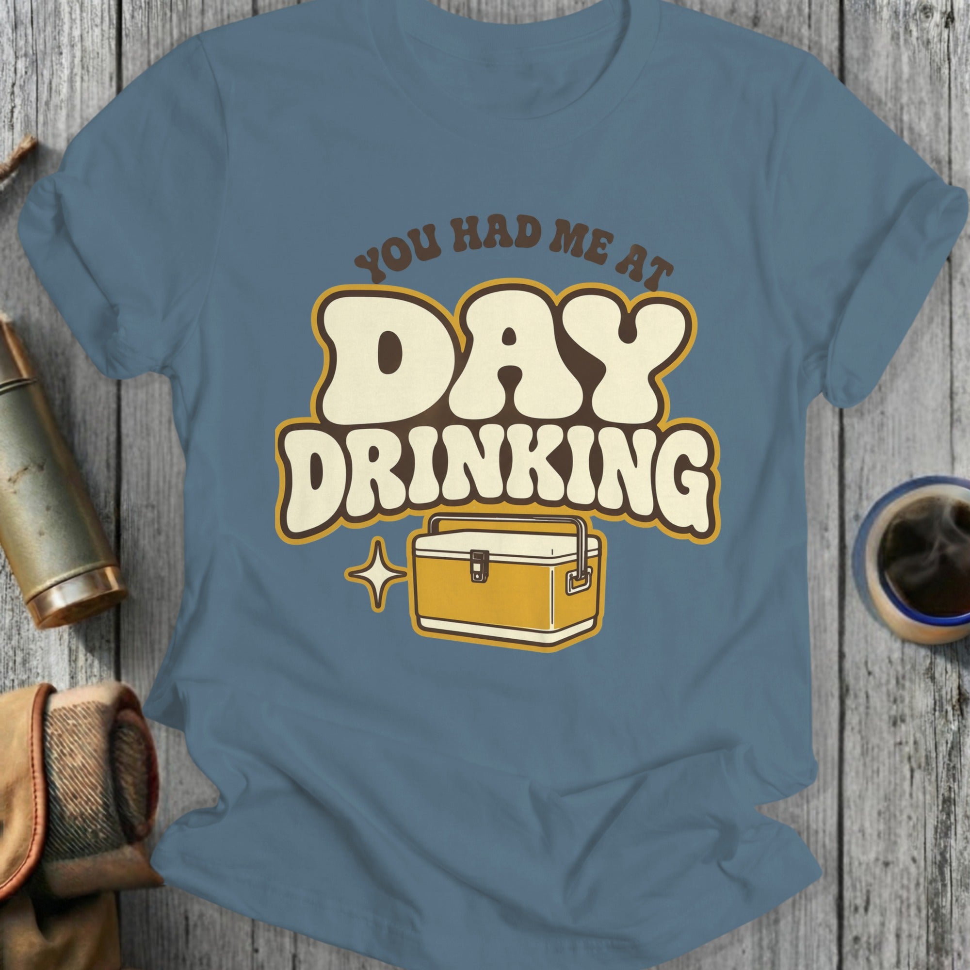 Blue t-shirt with "You Had Me At Day Drinking" and a cooler illustration.
