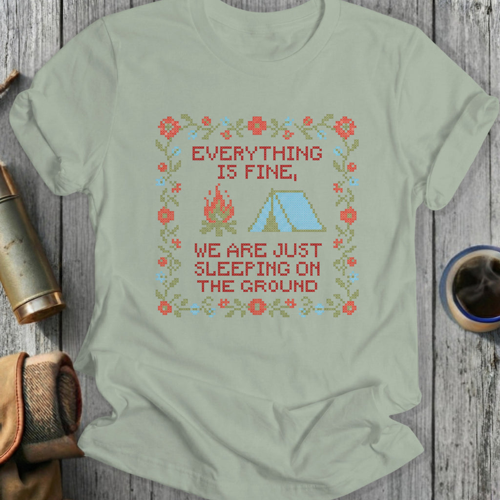 T-shirt with cross-stitch design: "Everything is fine, we are just sleeping on the ground."