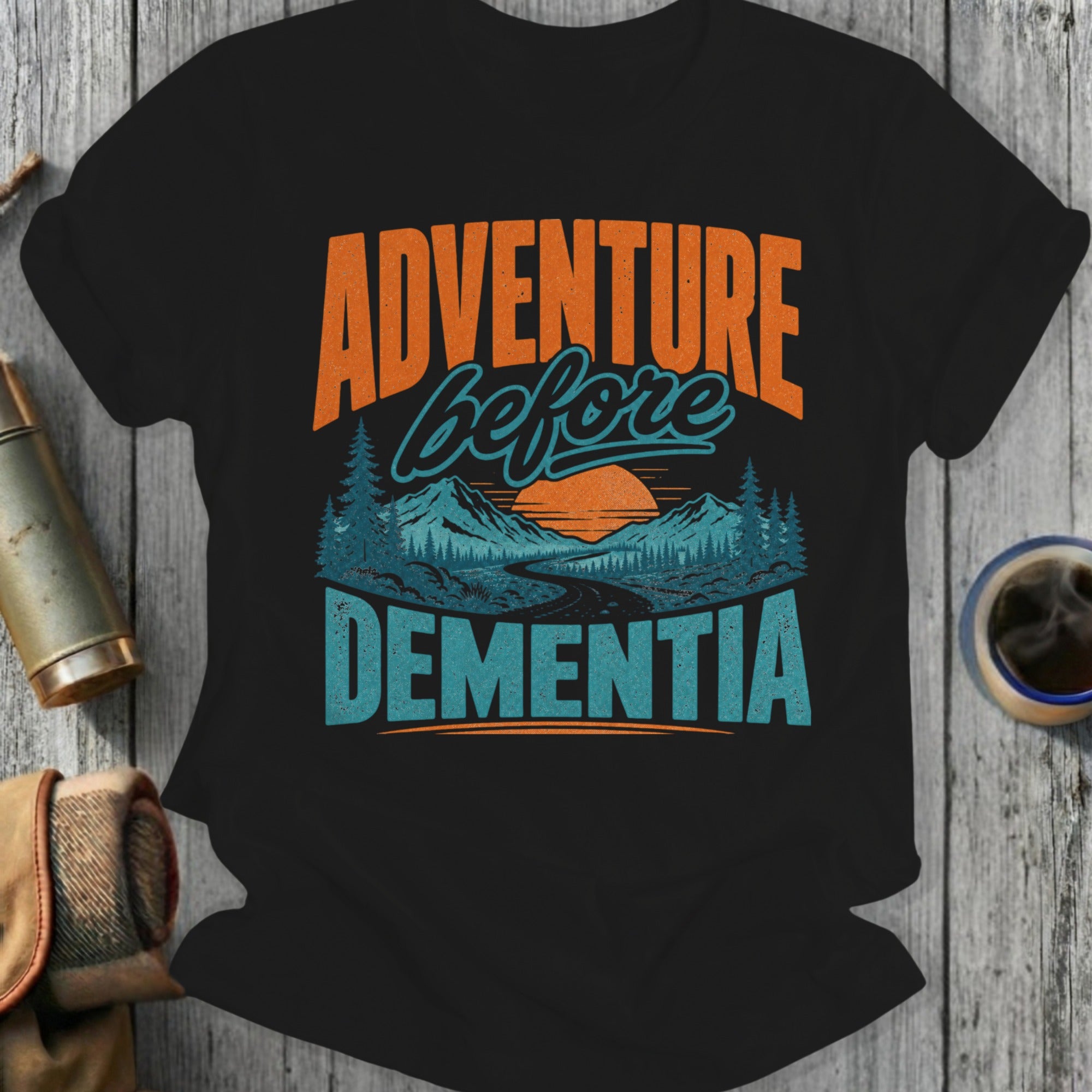Black t-shirt with "Adventure Before Dementia" text and mountain landscape graphic.