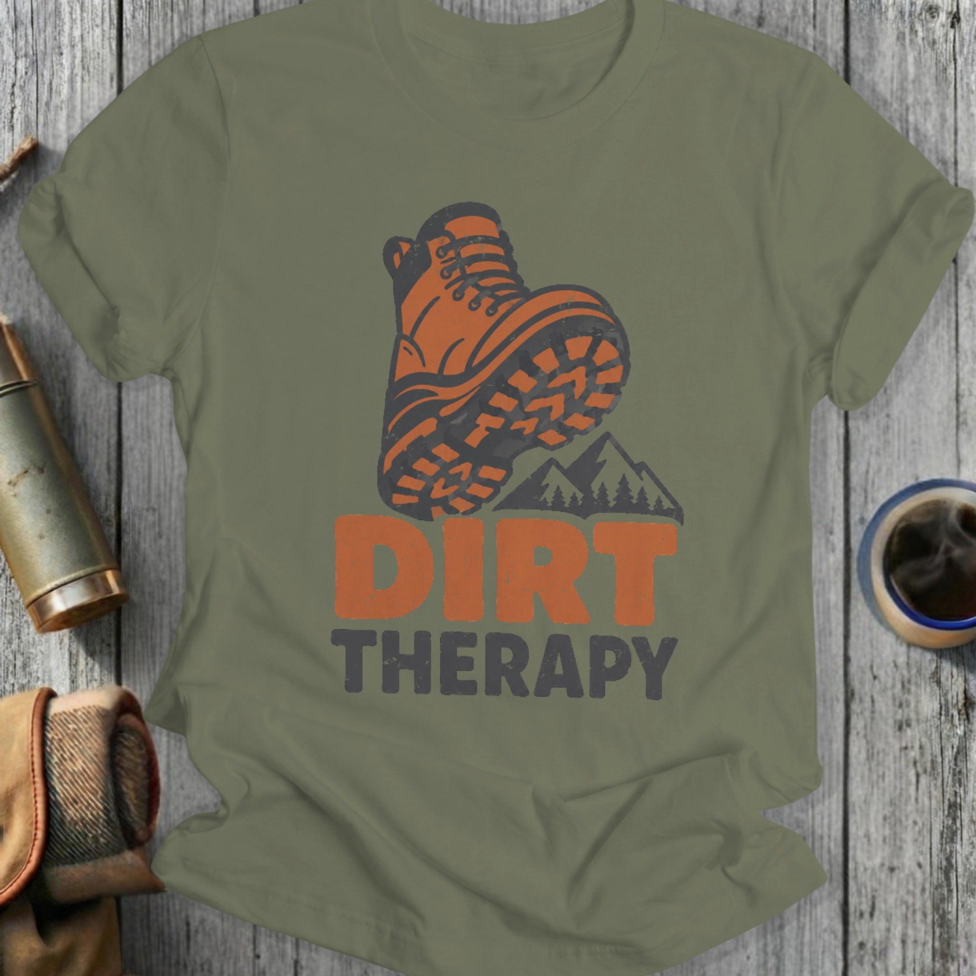 Orange hiking boot graphic with "DIRT THERAPY" text on a green t-shirt.