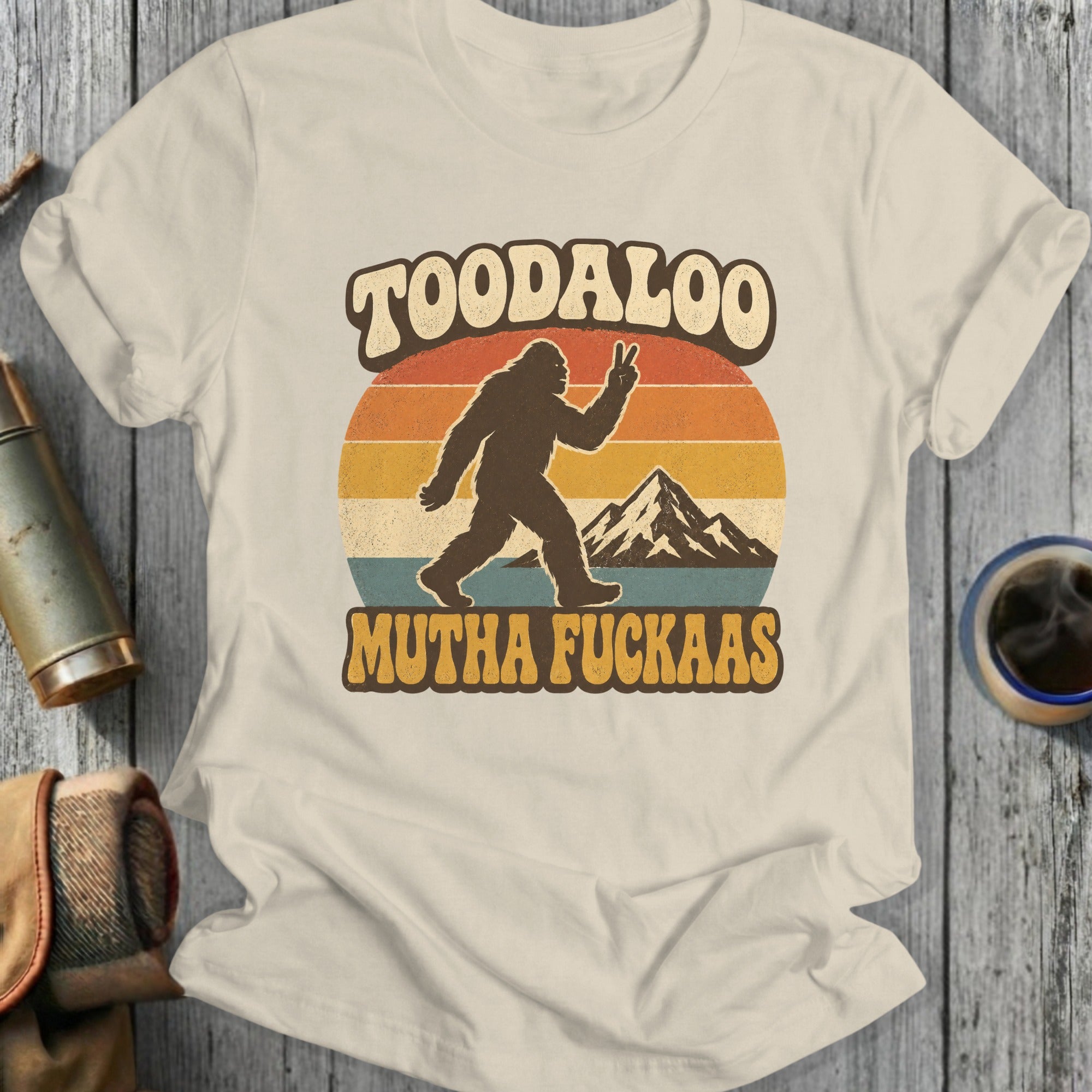 Bigfoot silhouette with peace sign and mountains, text "TOODALOO MUTHA FUCKAAS".