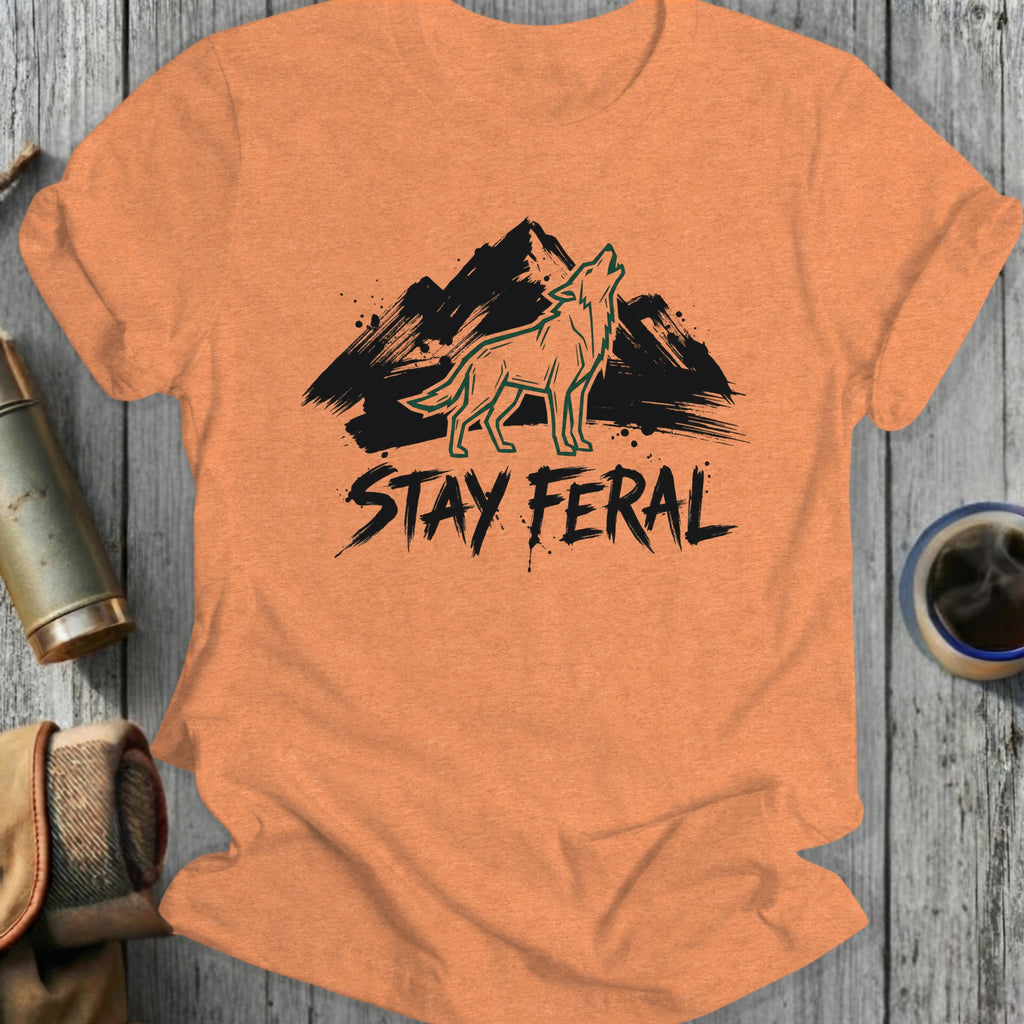 Orange t-shirt with black "STAY FERAL" text and howling wolf over mountains.