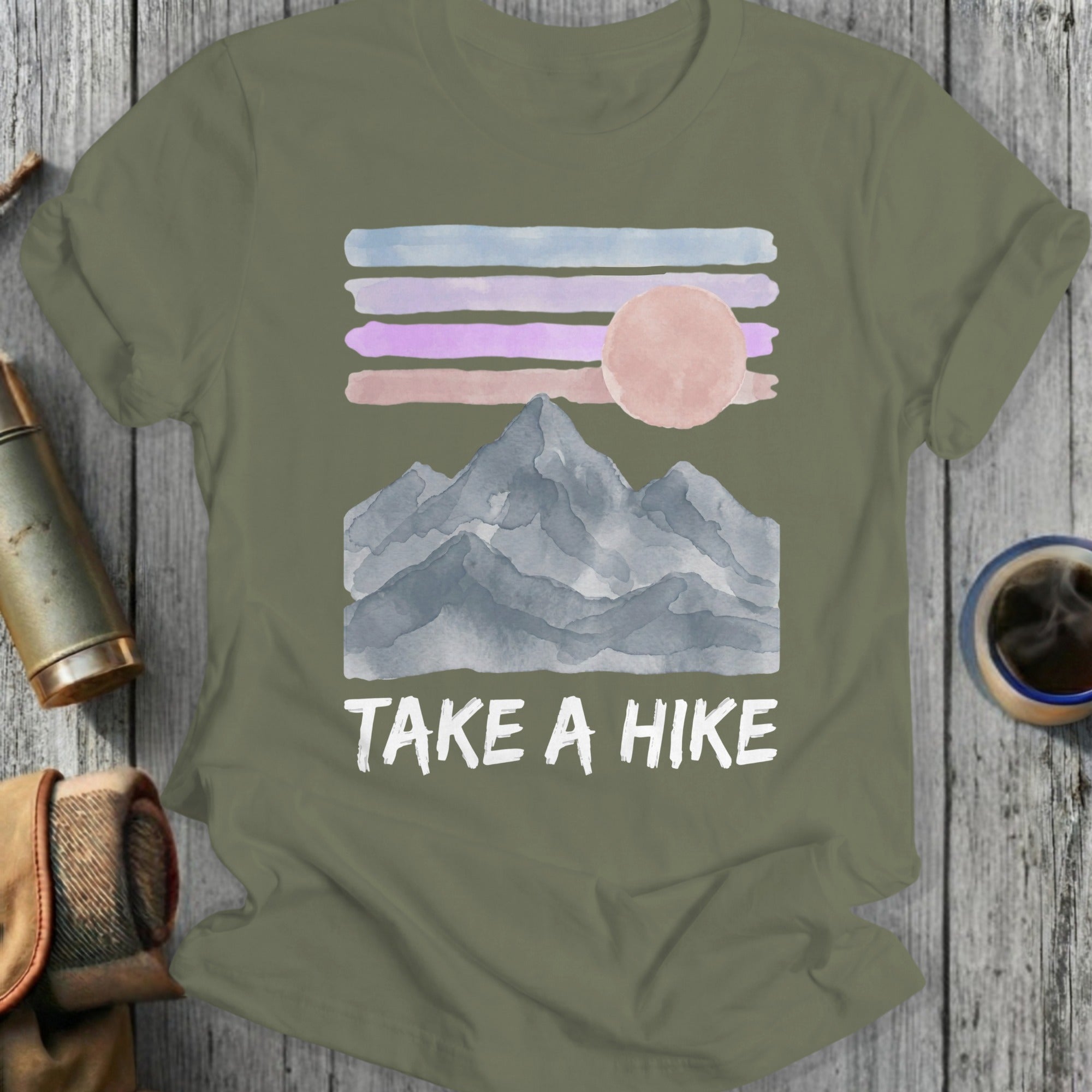 Olive green t-shirt with watercolor mountains, moon, and "Take a Hike" text.
