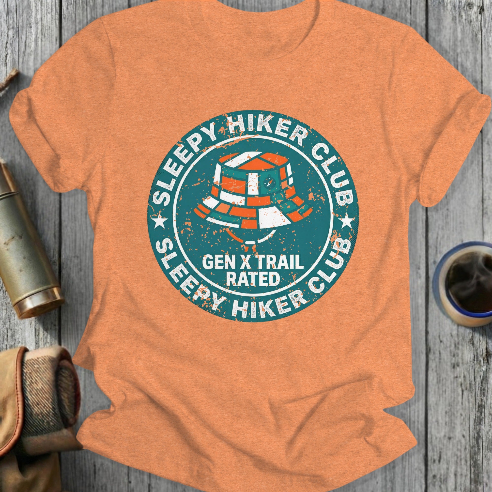 Orange t-shirt with "Sleepy Hiker Club Gen X Rated" text and bucket hat graphic.
