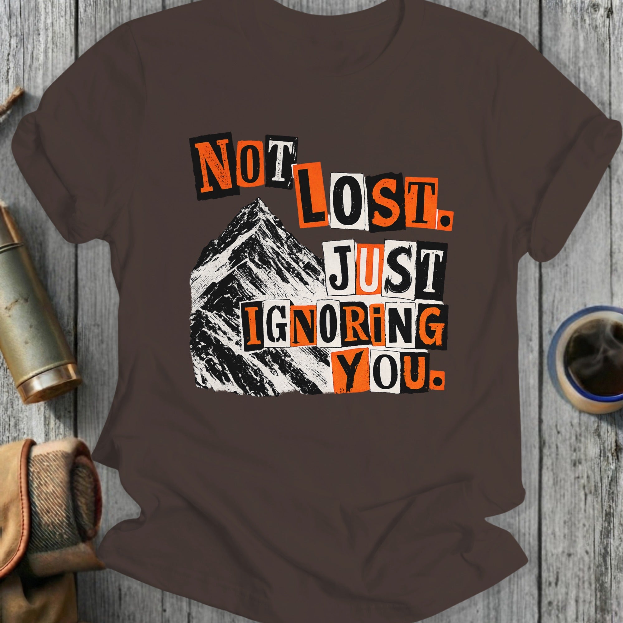T-shirt with "Not Lost. Just Ignoring You." text and mountain graphic.