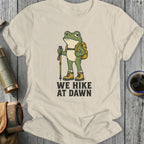 Frog with backpack, hiking pole, and boots printed with "WE HIKE AT DAWN".