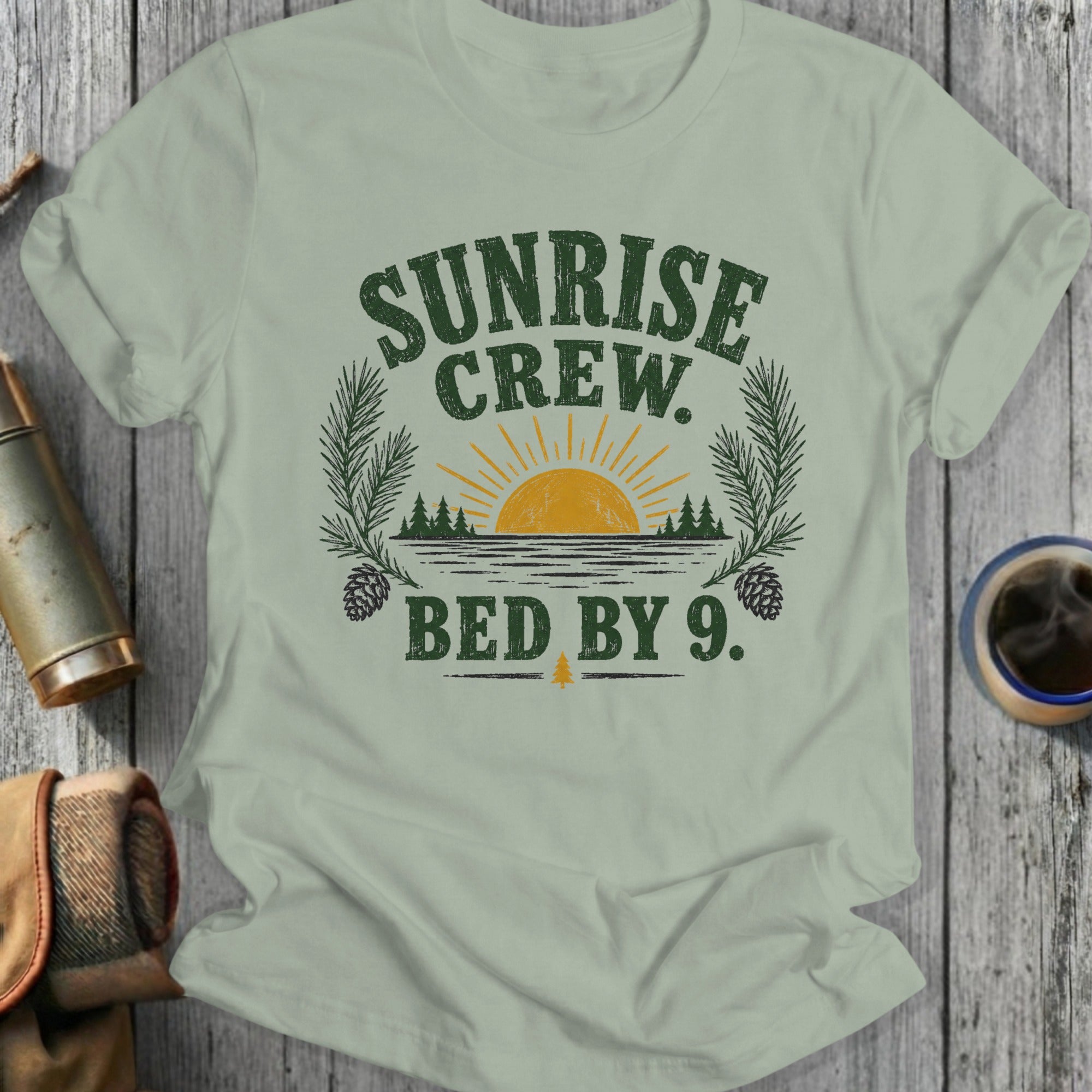 Light green t-shirt with "Sunrise Crew. Bed By 9." text and nature graphics.