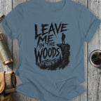 T-shirt with "Leave Me In The Woods" text and hiker on cliff overlooking forest.