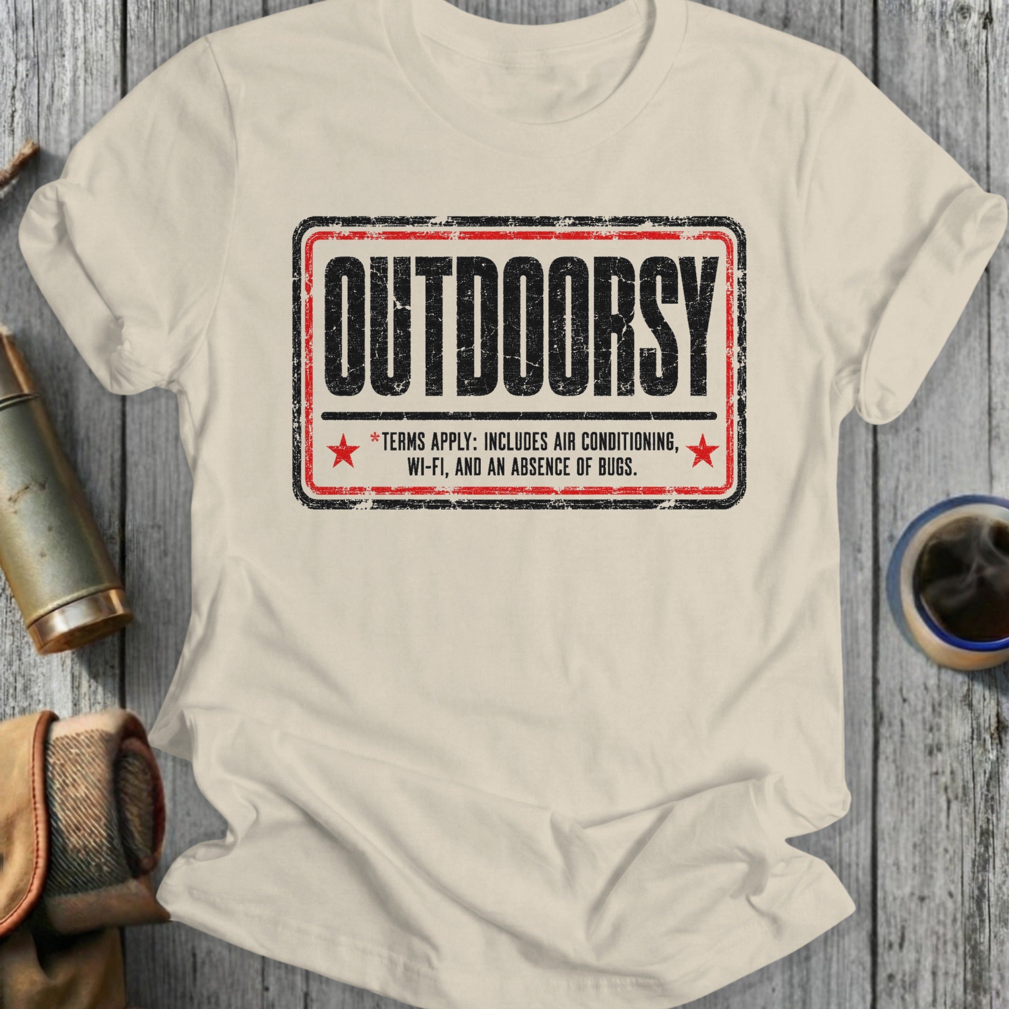 T-shirt with distressed graphic featuring the word "OUTDOORSY" and text about terms of service.
