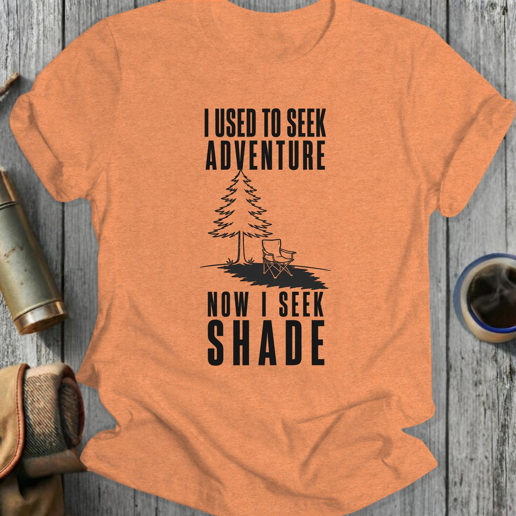 Orange t-shirt with black text "I USED TO SEEK ADVENTURE NOW I SEEK SHADE."