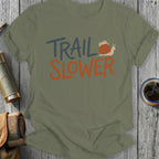 Olive green t-shirt with "TRAIL SLOWER" text and a snail graphic.