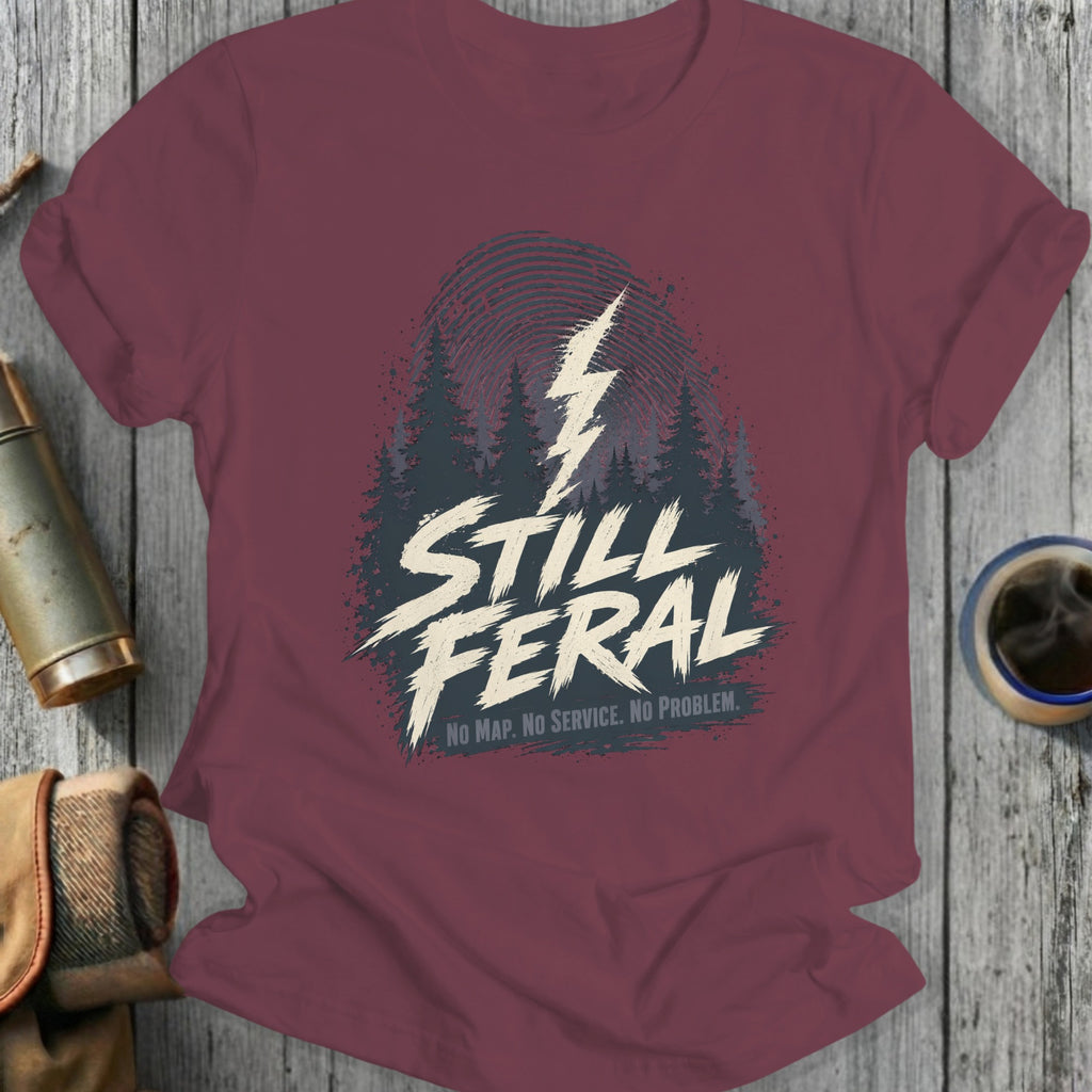 Maroon t-shirt with "STILL FERL" graphic and forest silhouette.