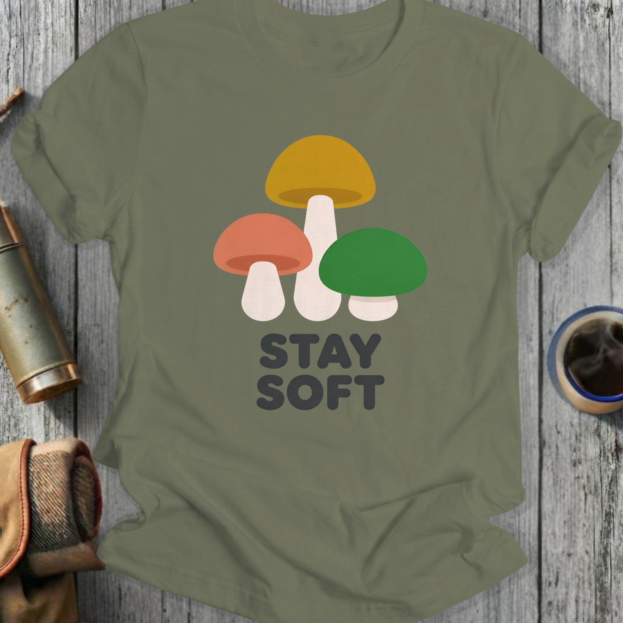 Olive green t-shirt with three colorful mushrooms and the text "STAY SOFT".