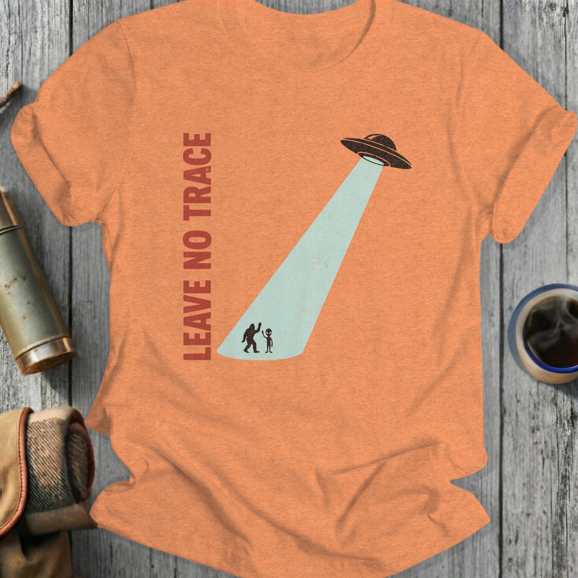 Orange t-shirt with UFO beaming down on Bigfoot and alien.