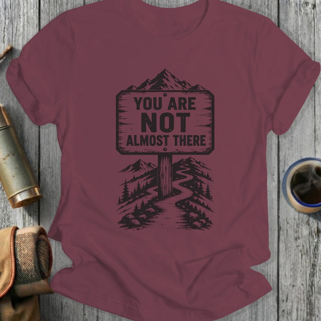 Maroon t-shirt with a signpost saying "You Are Not Almost There."