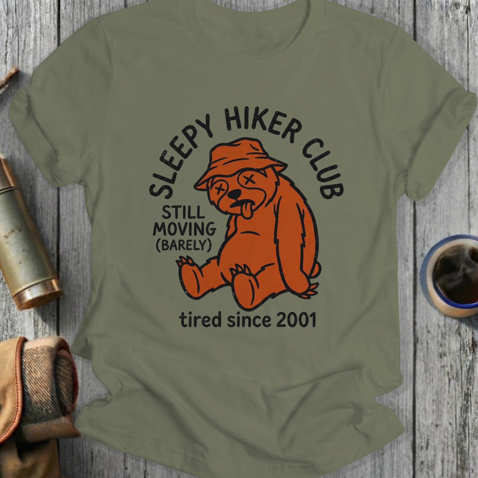 Orange bear wearing a hat, sitting and looking tired, text "Sleepy Hiker Club".