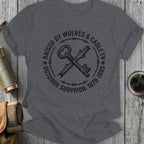Dark gray t-shirt with "Raised by Wolves & Cable TV Outdoor Survivor: 1970-1985" and a key graphic.