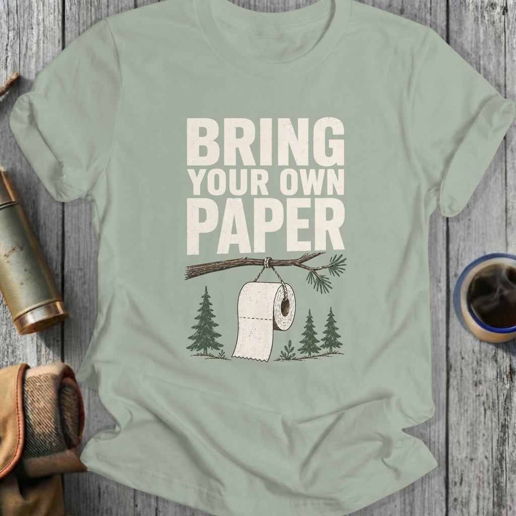 T-shirt with "Bring Your Own Paper" text and toilet paper on a tree branch.