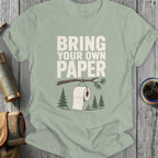 T-shirt with "Bring Your Own Paper" text and toilet paper on a tree branch.
