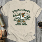 T-shirt with cartoon goose hiking, reads "GOOSE ON THE LOOSE. SHORT LEGS. SHORTER TEMPER."