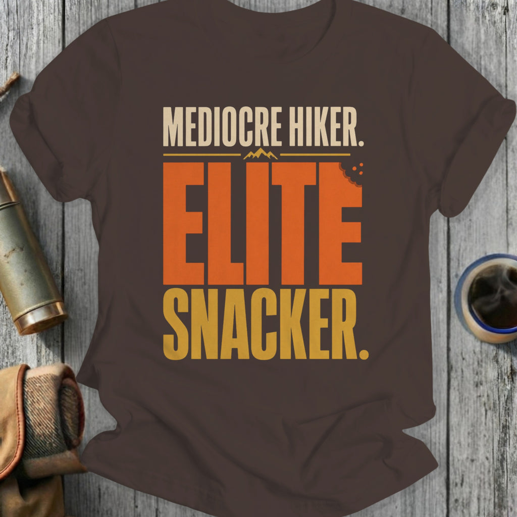 Brown t-shirt with text "Mediocre Hiker. Elite Snacker." and a bite mark.