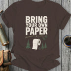 Brown t-shirt with "Bring Your Own Paper" text and toilet paper on a tree branch.