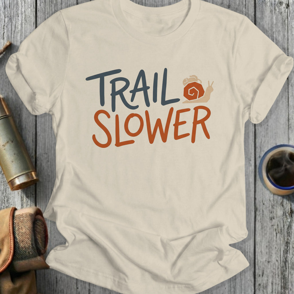 Cream t-shirt with "TRAIL SLOWER" text and a snail graphic.