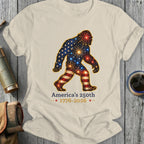 Bigfoot silhouette with American flag pattern, fireworks, and 1776-2026 text.