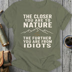 Olive t-shirt with white text and mountain graphic: "The closer you are to nature, the further you are from idiots."
